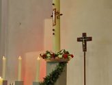 Altarraum mit Osterkerze und Vortragekreuz