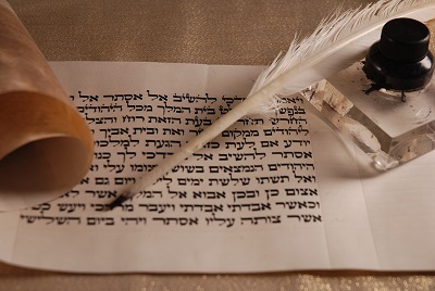mit hebräischen Buchstaben beschriebenes Blatt, daneben Feder und Tintenfass