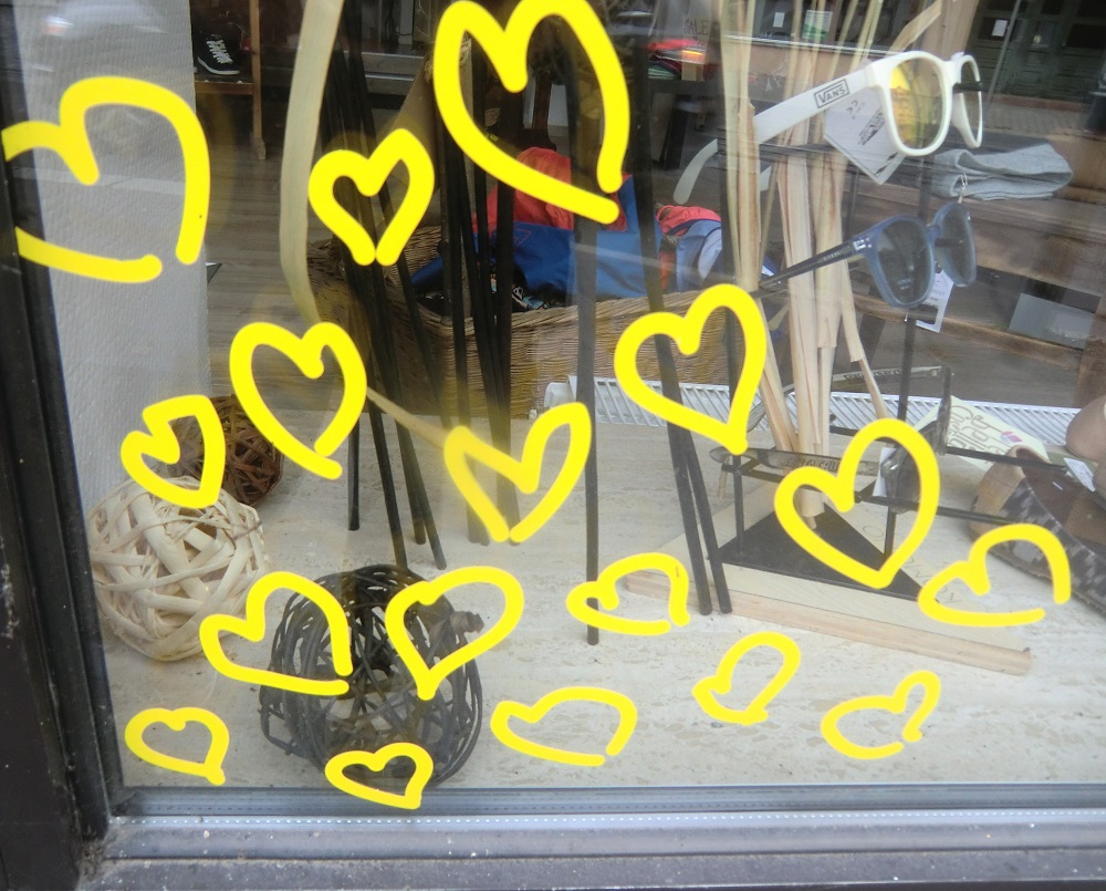 ein mit gelben Herzen beklebtes Schaufenster eines Optikers