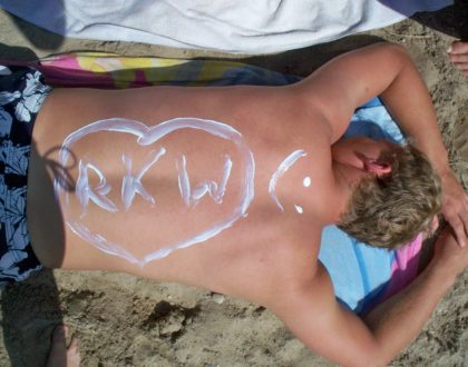 auf dem sonnengebräunten Rücken steht mit Sonnenmilch geschrieben: RKW und ein Smily