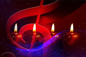 vier Kerzen schimmern hinter einem überdimensionalen Notenschlüssel