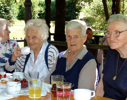 vier Seniorinnen beim Kaffeekränzchen im Freien